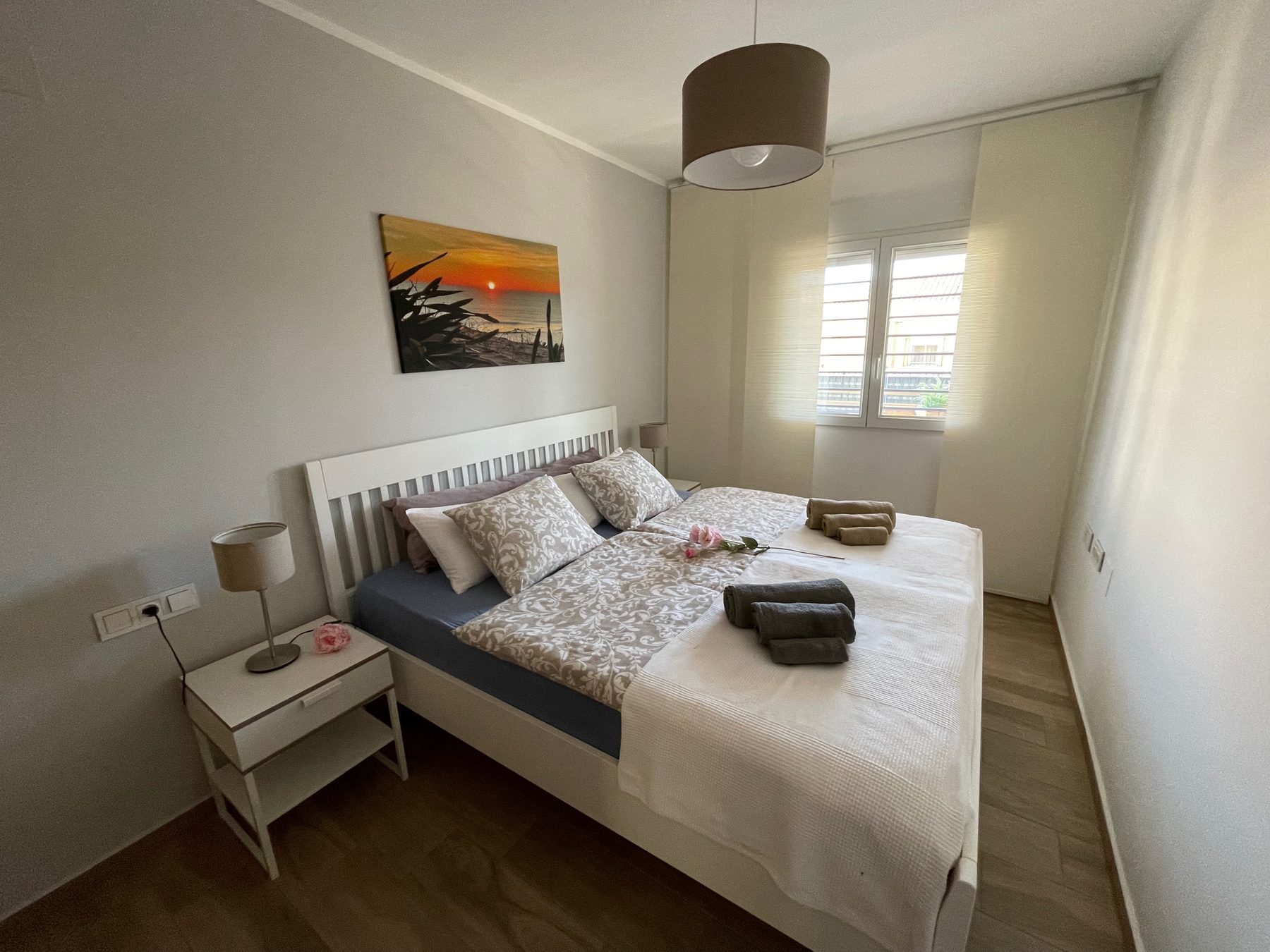 Schlafzimmer mit Doppelbett, hellen Waenden und Fenster